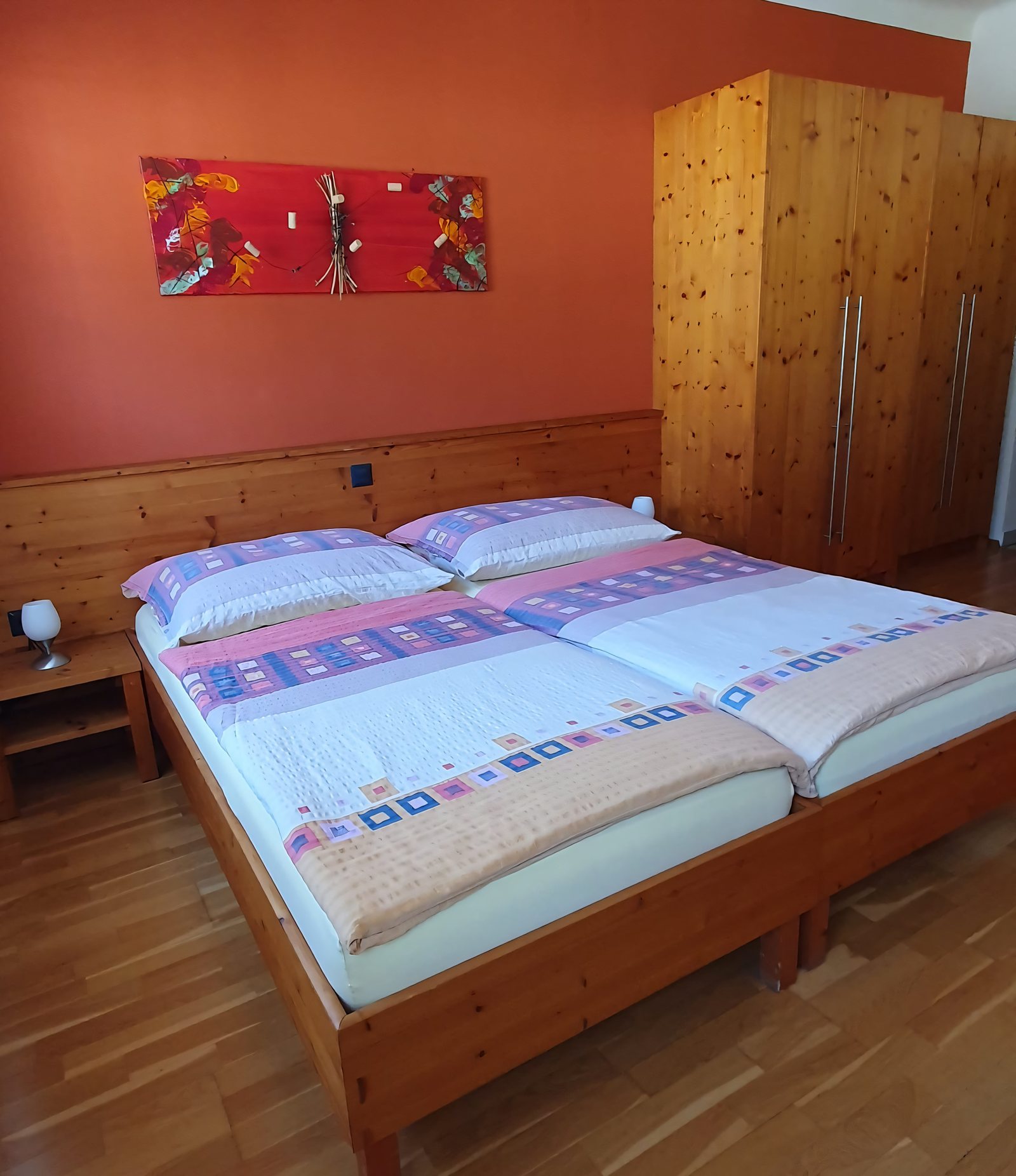 Doppelzimmer mit Holzbetten und Kleiderschrank